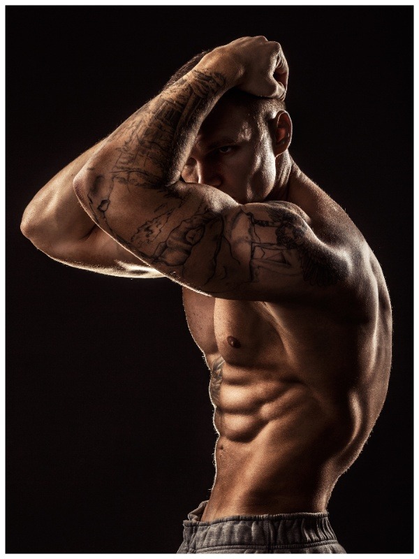 muscular man with tattoo poses