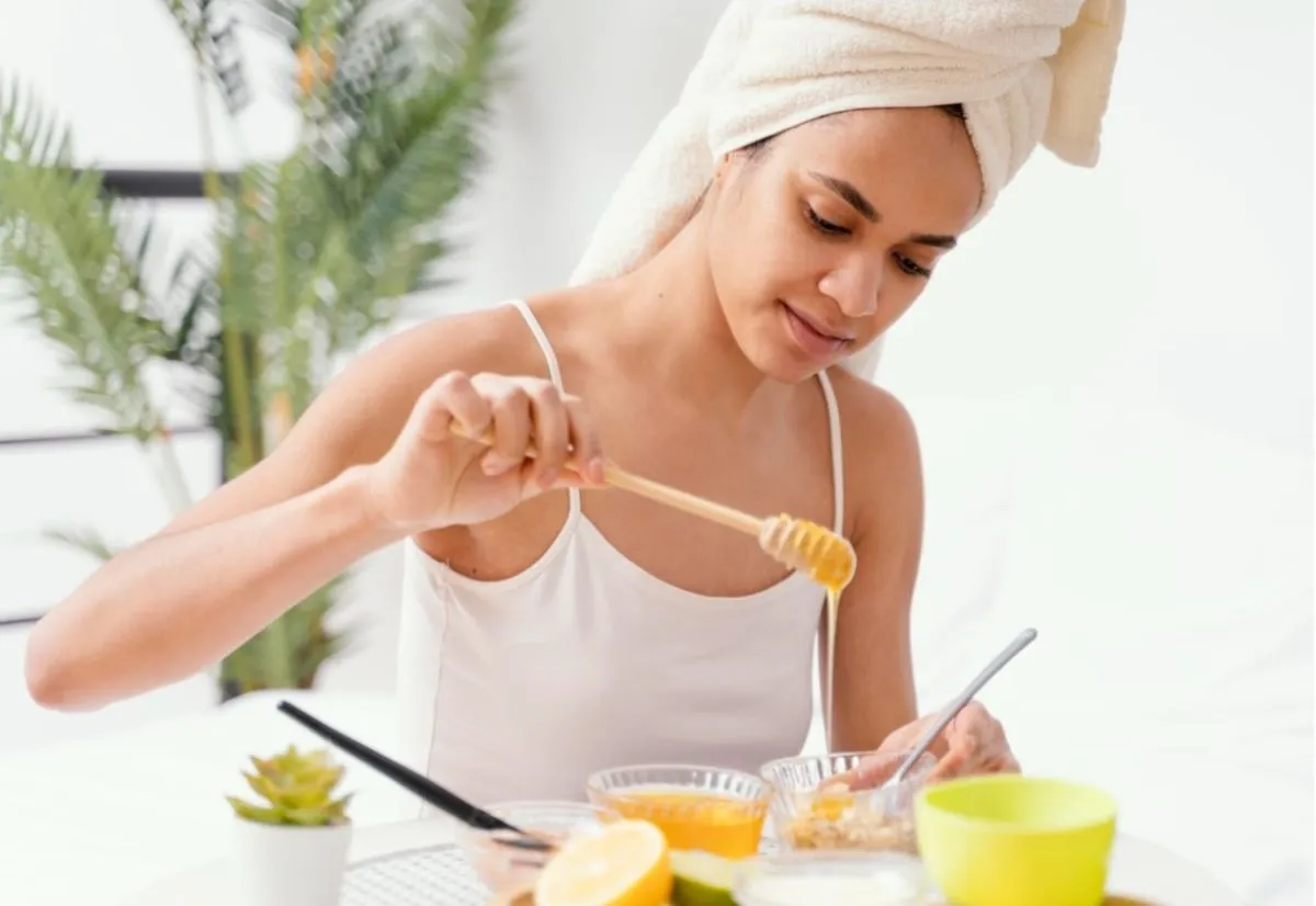 a woman is making a face mask with honey