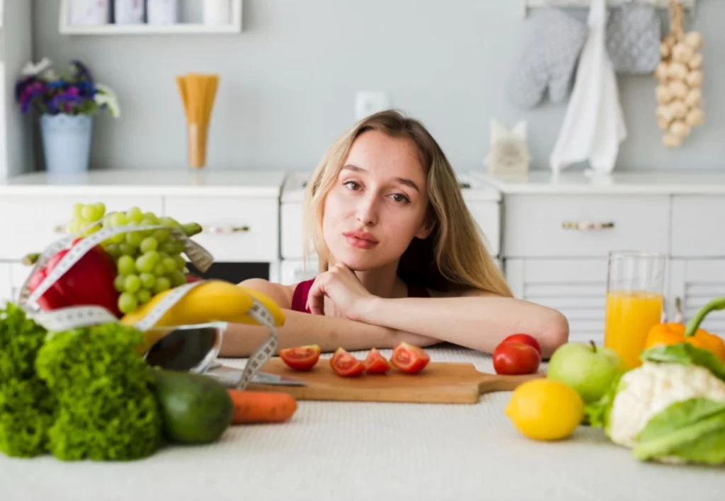 Diet concept with sporty woman in kitchen